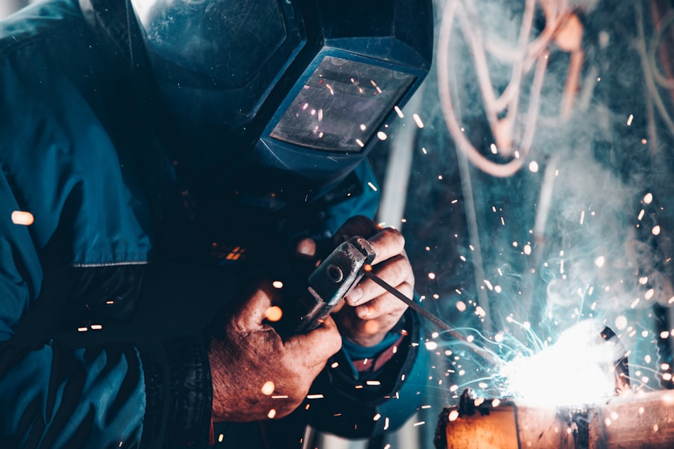 Plumber soldering a copper pipe joint with sparks