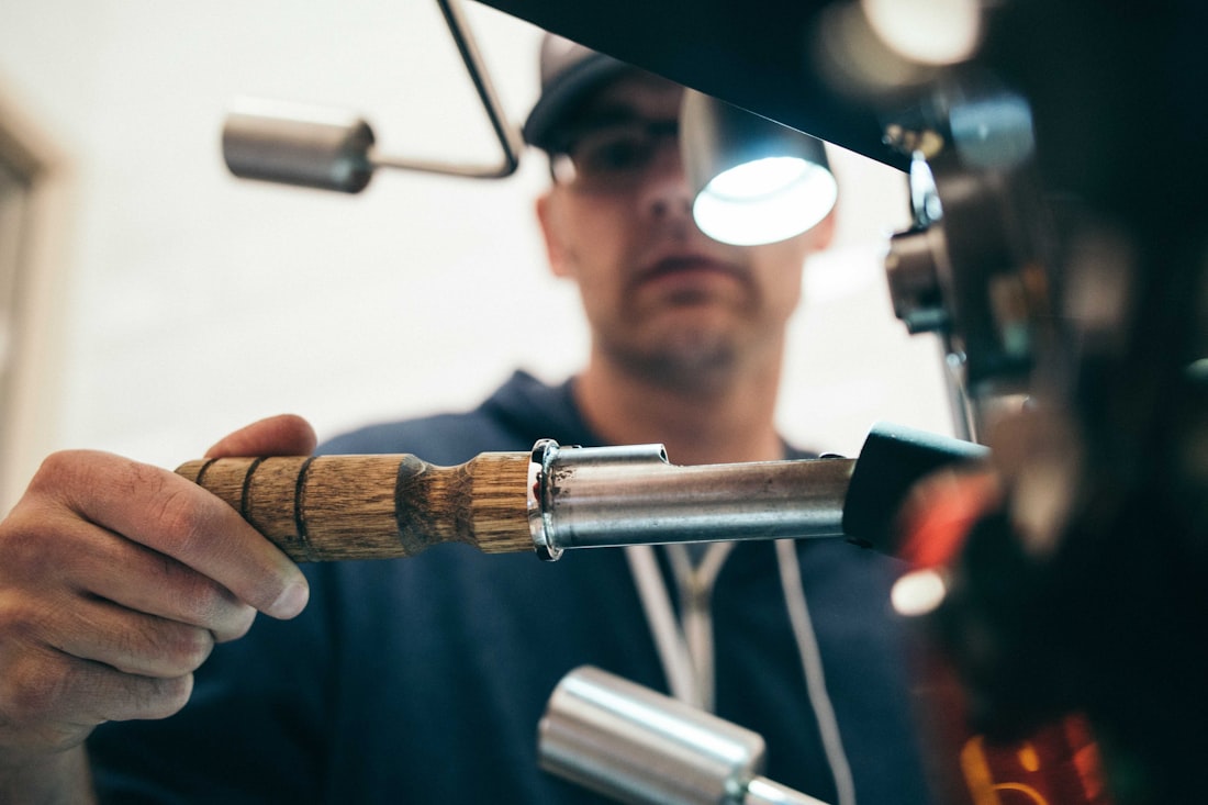 Licensed plumber fitting a polished metal pipe section on the job